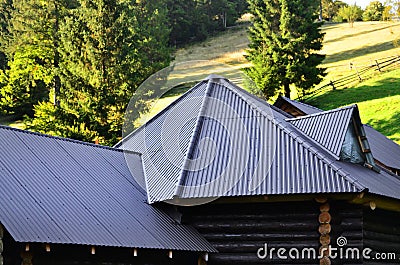The roof is made of gray embossed metal sheets. Wooden house in the summer fiel Stock Photo