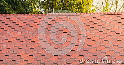 Roof with red bitumen shingles. Modern types of roofing materials Stock Photo