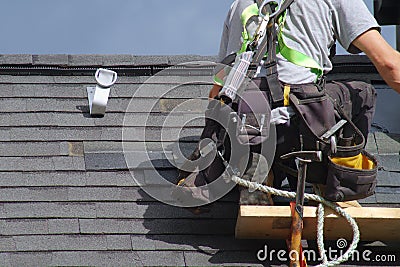 Roofer construction roof repair rope security worker Stock Photo