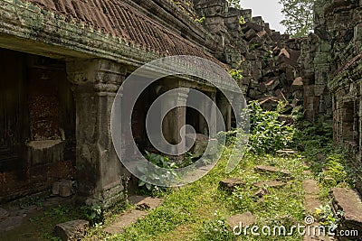 Roofed colonnade leading to pile of rocks Stock Photo