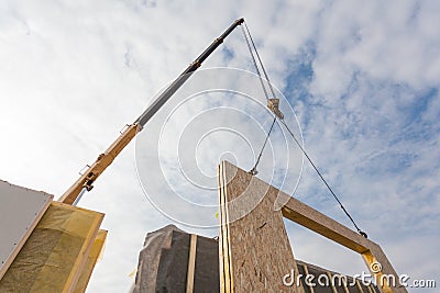 Roofer builder worker with crane installing structural Insulated Panels SIP. Building new frame energy-efficient house. Stock Photo