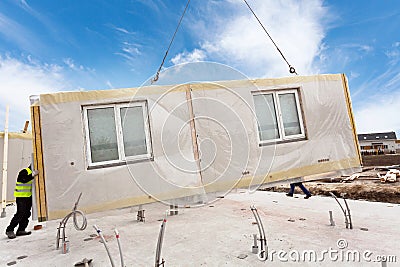 Roofer builder workers with crane installing structural Insulated Panels SIP. Building new frame energy-efficient house. Stock Photo