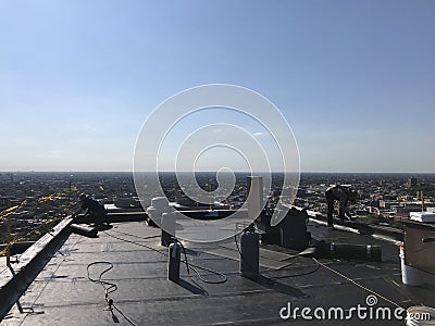 Roofer and a crew working on a smooth modified flat roof. Workers. Editorial Stock Photo