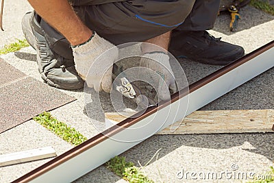 Roofer cuts profile on metal scissors. Stock Photo