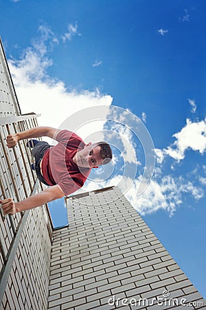 Roofer descends stairs from roof Stock Photo