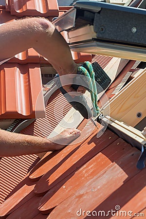 Roofer installs a skylight on the new roof using a drill. Stock Photo