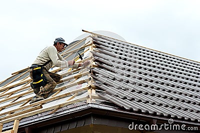 Roofer laying tiles Stock Photo