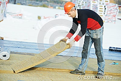 Roofer worker installing roof insulation material Stock Photo