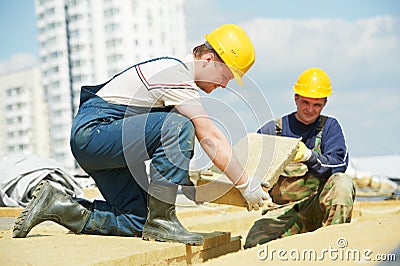 Roofer worker installing roof insulation material Stock Photo