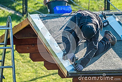 Roofer worker using battery-powered gun Stock Photo