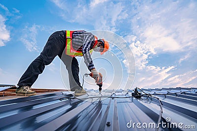 Roofer working on roof structure of building in construction site, .Roof metal sheet construction concept Stock Photo