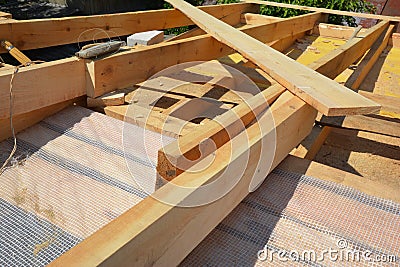 Roofing construction. A close up of roof wood framing with ceiling joists and rafters installation over the waterproof barrier Stock Photo
