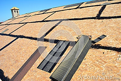 Roofing construction. Preparing a osb roof deck with bitumen waterproofing in cracks before underlayment, felt paper and asphalt Stock Photo