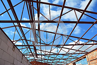 Roofing construction. Steel roof trusses details with clouds sky background. Stock Photo