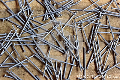 Roofing nails scattered on the wooden flooring. Stock Photo