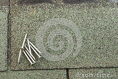 Roofing nails on shingle Stock Photo