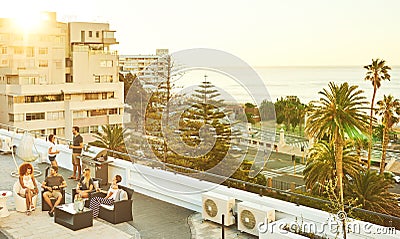 Rooftop barbaque at sunset with group of attractive young adults Stock Photo