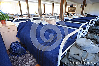 At the room of the barrack: soldier sleeping in his bed, well-made beds, nightstands and benches around. Novo-Petrivtsi Editorial Stock Photo