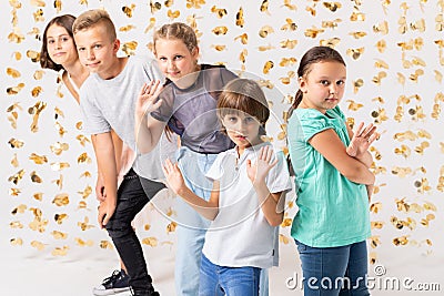 golden decorations and group of cool kids fooling around and making funny poses Stock Photo