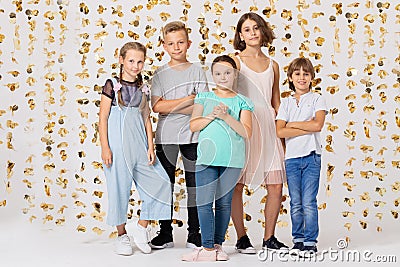 Room with golden decorations and group of cool kids fooling around and making funny poses Stock Photo