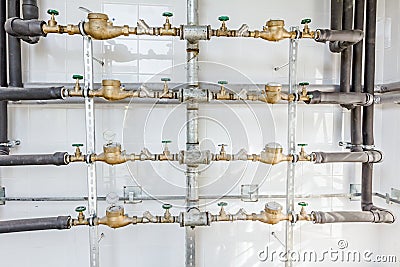 Room with lined up water meters, pipes and valves Stock Photo