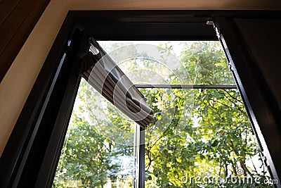 Room ventilation, airing the room with open window, sun rays through the leaves of the trees shining into the room Stock Photo