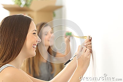 Roommates measuring and moving home Stock Photo