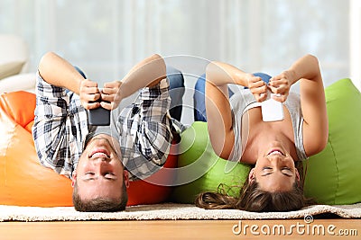 Roommates online with smart phones upside down Stock Photo