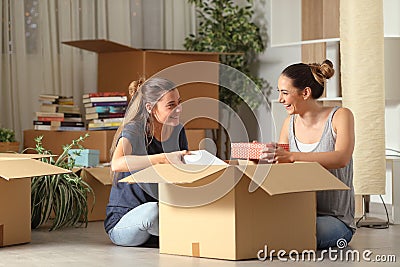 Roommates talking unboxing gelongings moving home Stock Photo