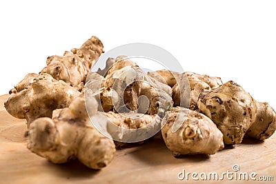 Roots of Jerusalem artichokes close up. Tubers od Jerusalem artichokes on a wooden table Stock Photo