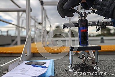 Engineer conducting using pull machinery testing chemical set fall arrest fall restraint abseiling anchor point Stock Photo