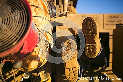 Rope access miner wearing safety boot harness, helmet entering into confined space Stock Photo