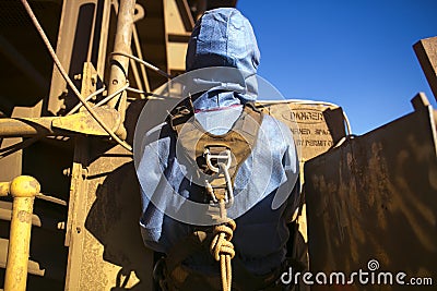 Rope access miner wearing safety harness connecting into Karabiner which attached on rope the back of his harness loop as rescue p Stock Photo