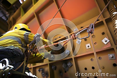 Rope access miner working at height hanging on harness commencing chute repairs which have secondary safety back up device knowing Stock Photo