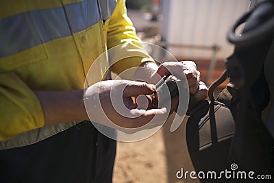 Rope access technician male hand inspector commencing inspection buckle leg belt strap safety harness Stock Photo