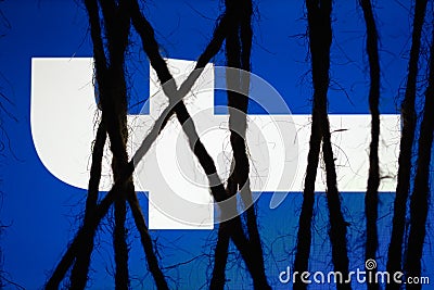 Rope bondage with a glowing blue screen with white logo of `facebook`. Concept of censorship Editorial Stock Photo