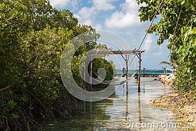 Rope hammocks suspended above lagoon water on tropical island vacation paradise for relaxing. Stock Photo