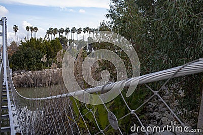 Rope handrails of the bridge extending into the distance Stock Photo