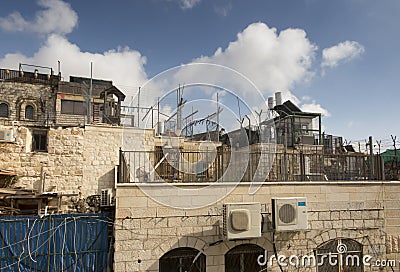 Ropes, cables, wires, pipes, air conditioners, tanks, various installations on the walls and roofs of Jerusalem Editorial Stock Photo