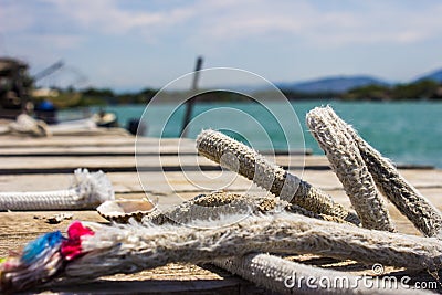 Ropes on a wooden pier on the background of the sea, mountains in Montenegro Stock Photo