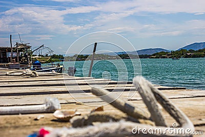 Ropes on a wooden pier on the background of the sea, mountains in Montenegro Stock Photo