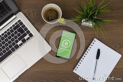 Whatsapp business on phone screen. Top view of workspace. Table desk with laptop, mobile Editorial Stock Photo