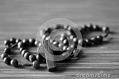 The Rosary. Close up of wooden rosary beads with Jesus Christ holy cross Crucifix on the table in black and white background. Stock Photo