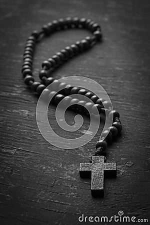 Rosary with cross on dark wooden background. black and white photography Stock Photo