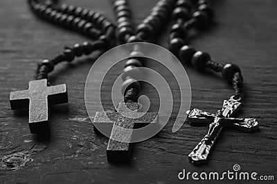 Rosary with cross on dark wooden background. black and white photography Stock Photo