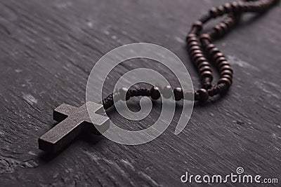 Rosary with cross on dark wooden background. Stock Photo