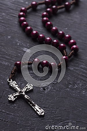 Rosary with cross on dark wooden background. Stock Photo