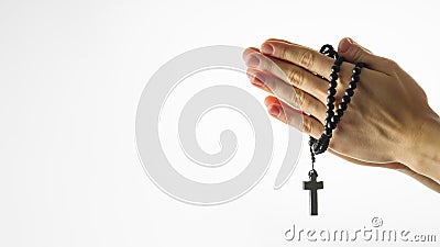 Rosary and crucifix in female hands on a white background. Hands folded for prayer. Religion, Catholicism, prayer, faith, Stock Photo