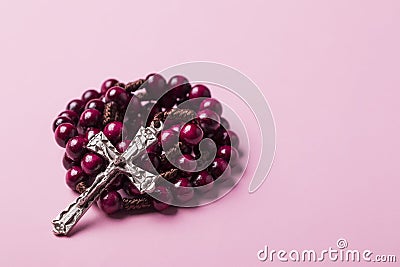 Rosary on a pink background. Cross. Stock Photo