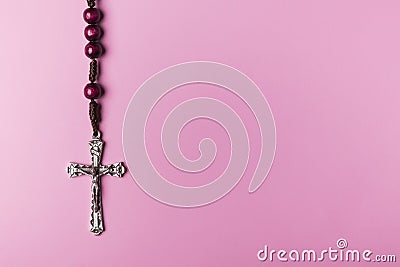 Rosary on a pink background. Cross. Stock Photo